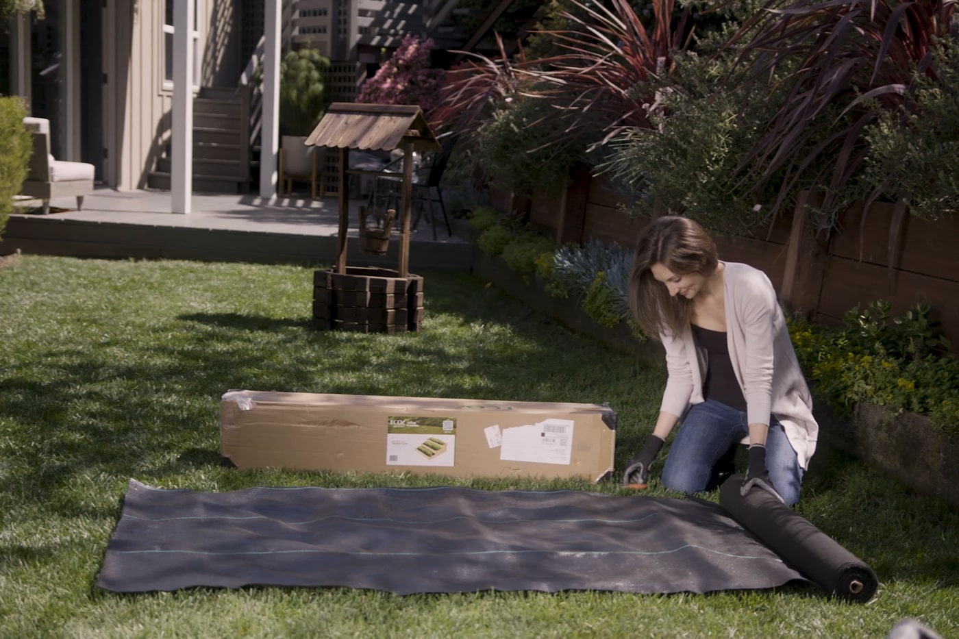 woman laying out landscape fabric