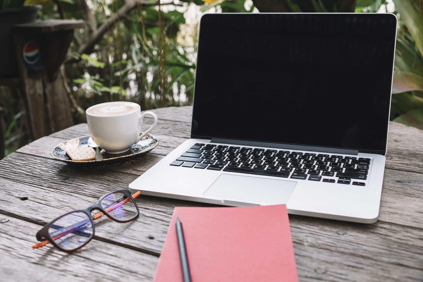 A laptop and notebook in a table