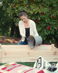 Woman adding soil to the Ecogardener Raised Bed