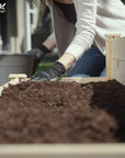 A woman putting soil in the Ecogardener tiered raised bed planter