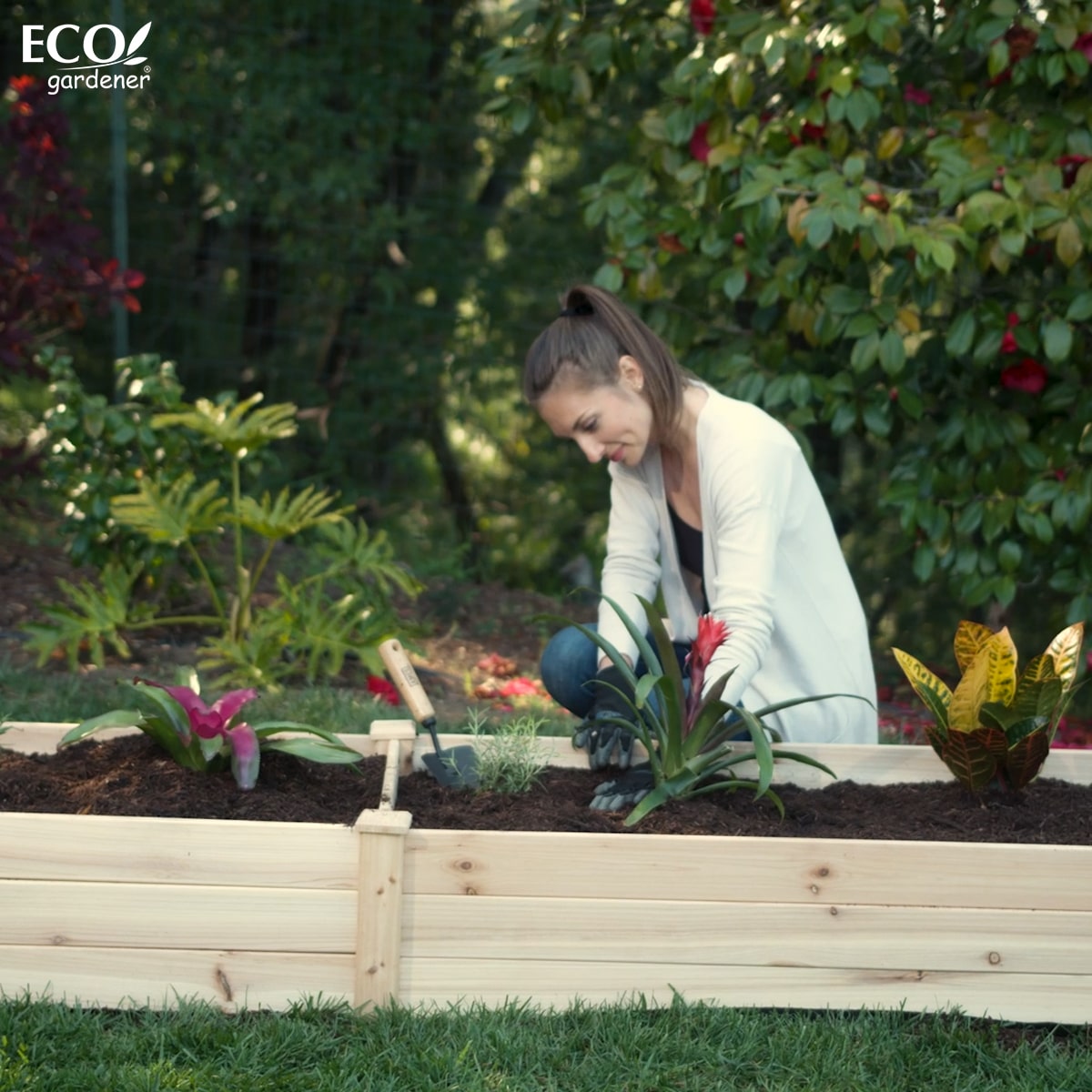 A woman planting in an Ecogardener Raised Bed.