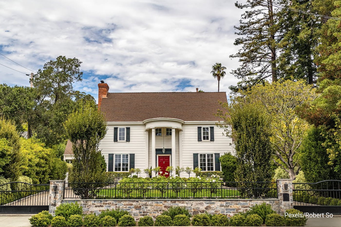 gated house façade with trim bush 