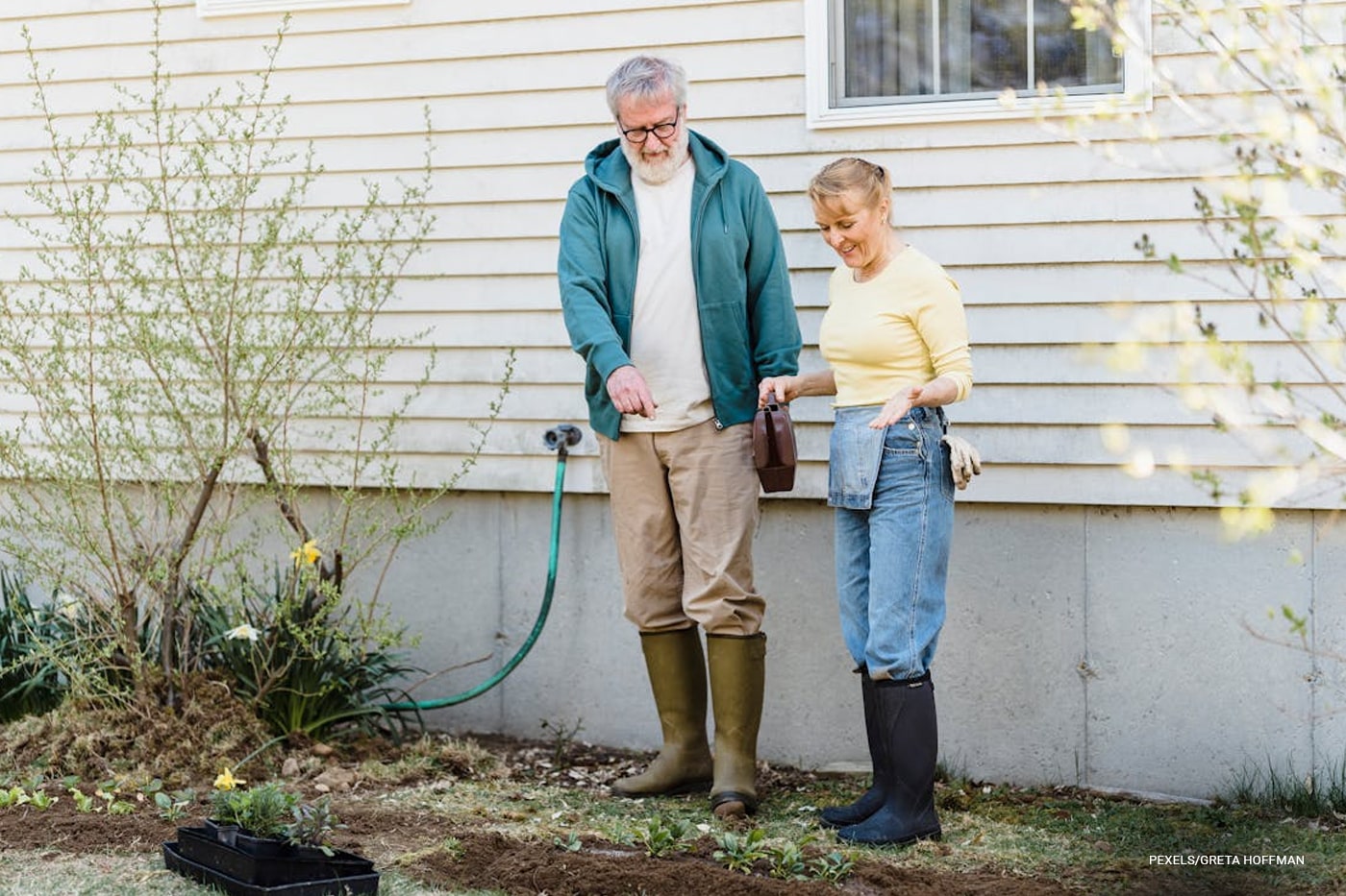 elderly couple seeing seedlings at the backyard 