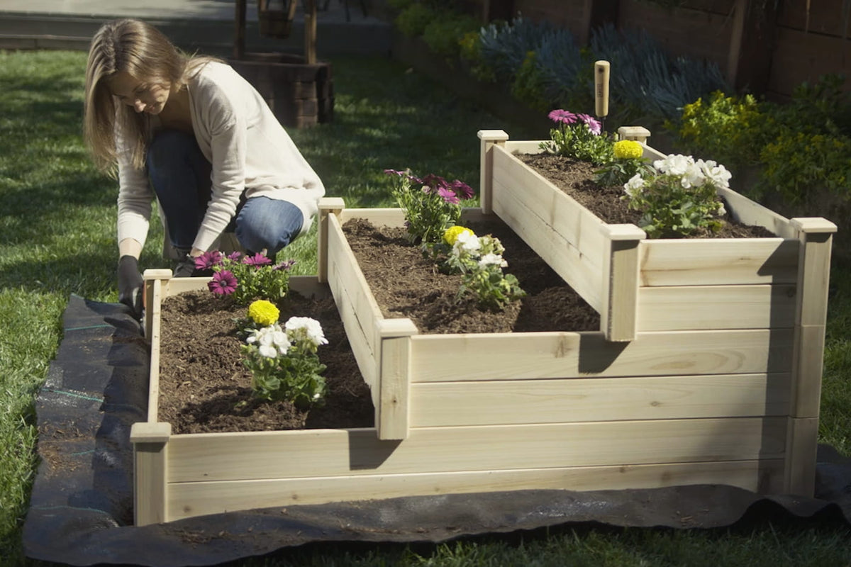 woman installing raised bed with landscape fabric on the bottom