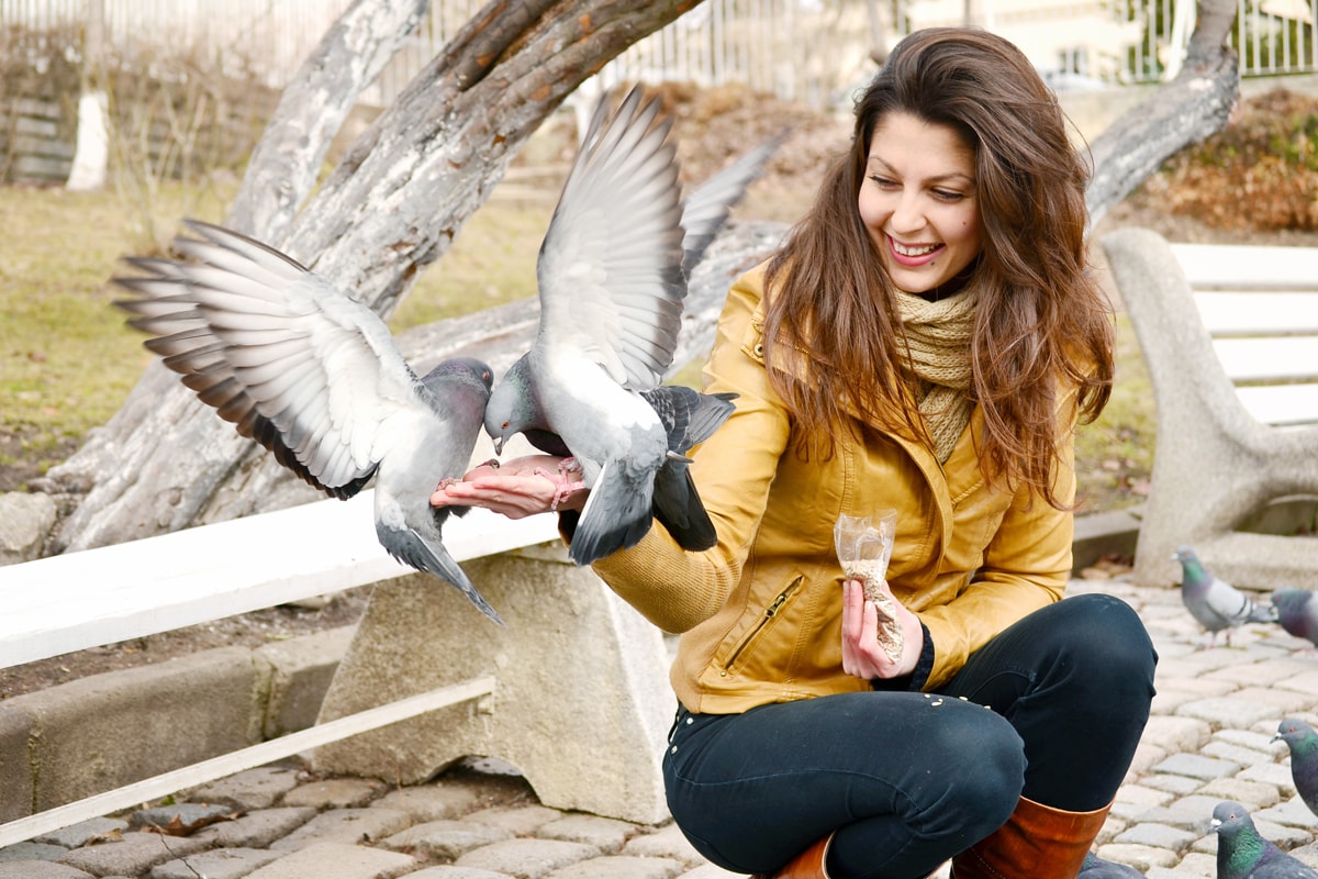 Woman feeding bird in winter