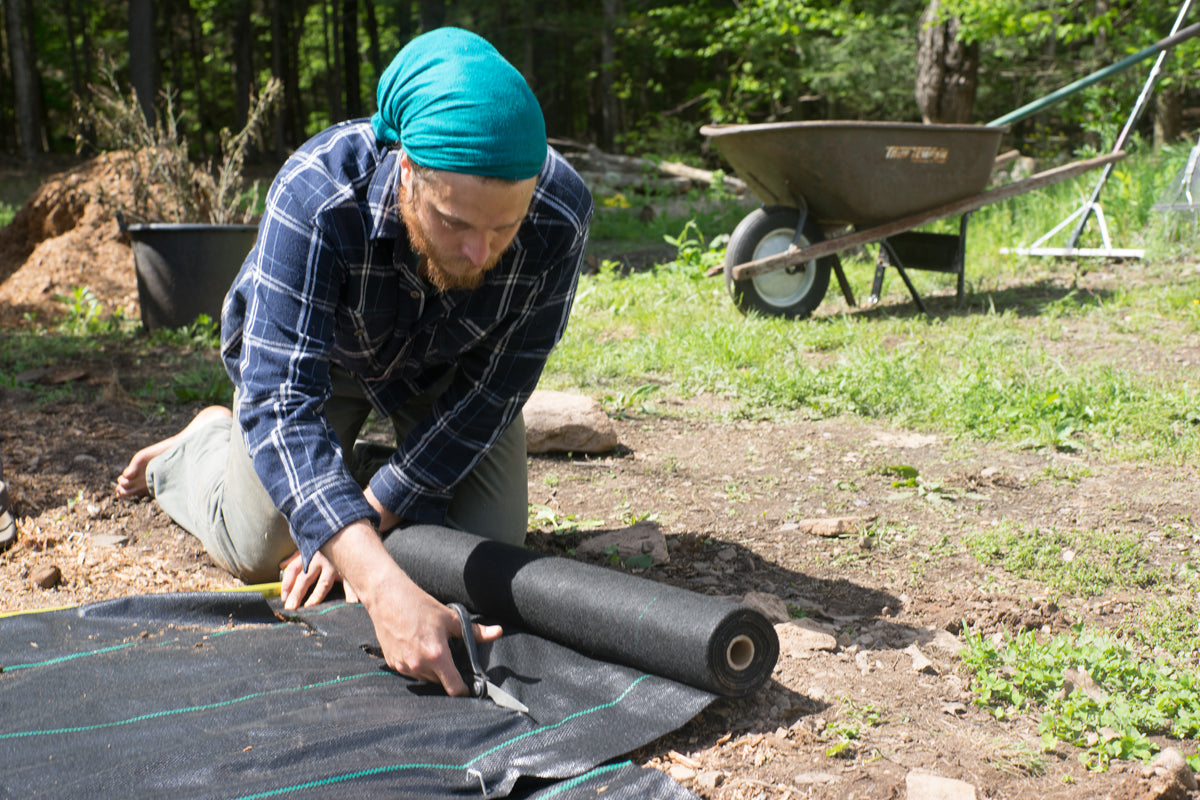 A man using Ecogardener Landscape Fabric