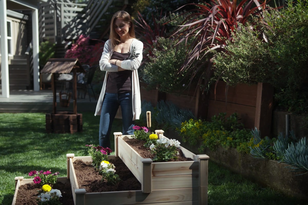 Woman looking at her raised bed garden