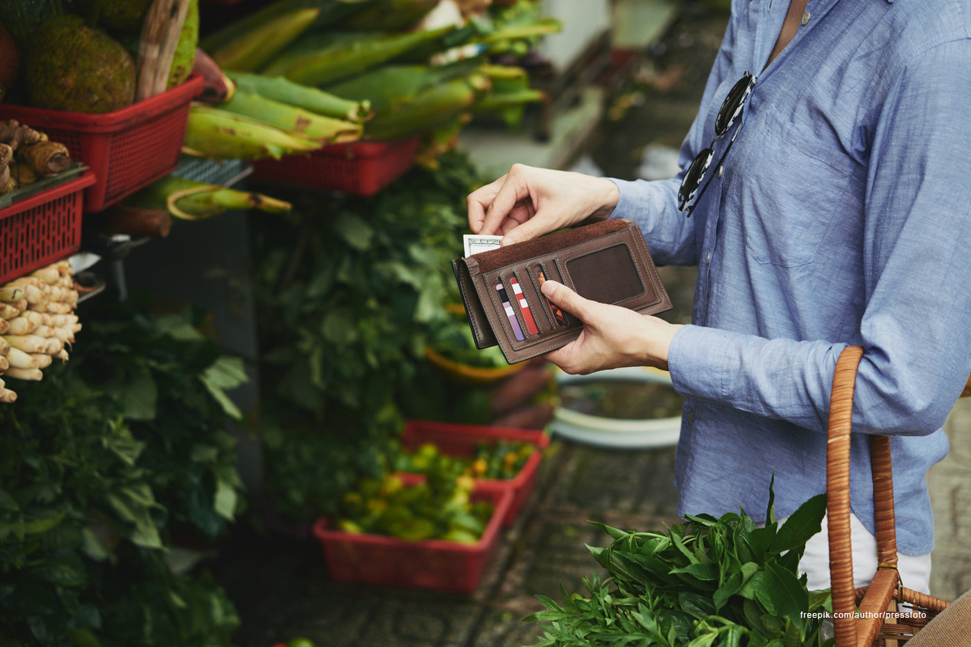 A person taking out their wallet to pay in a garden setting