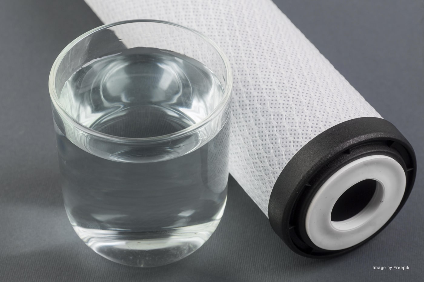 A glass of water beside a water filter