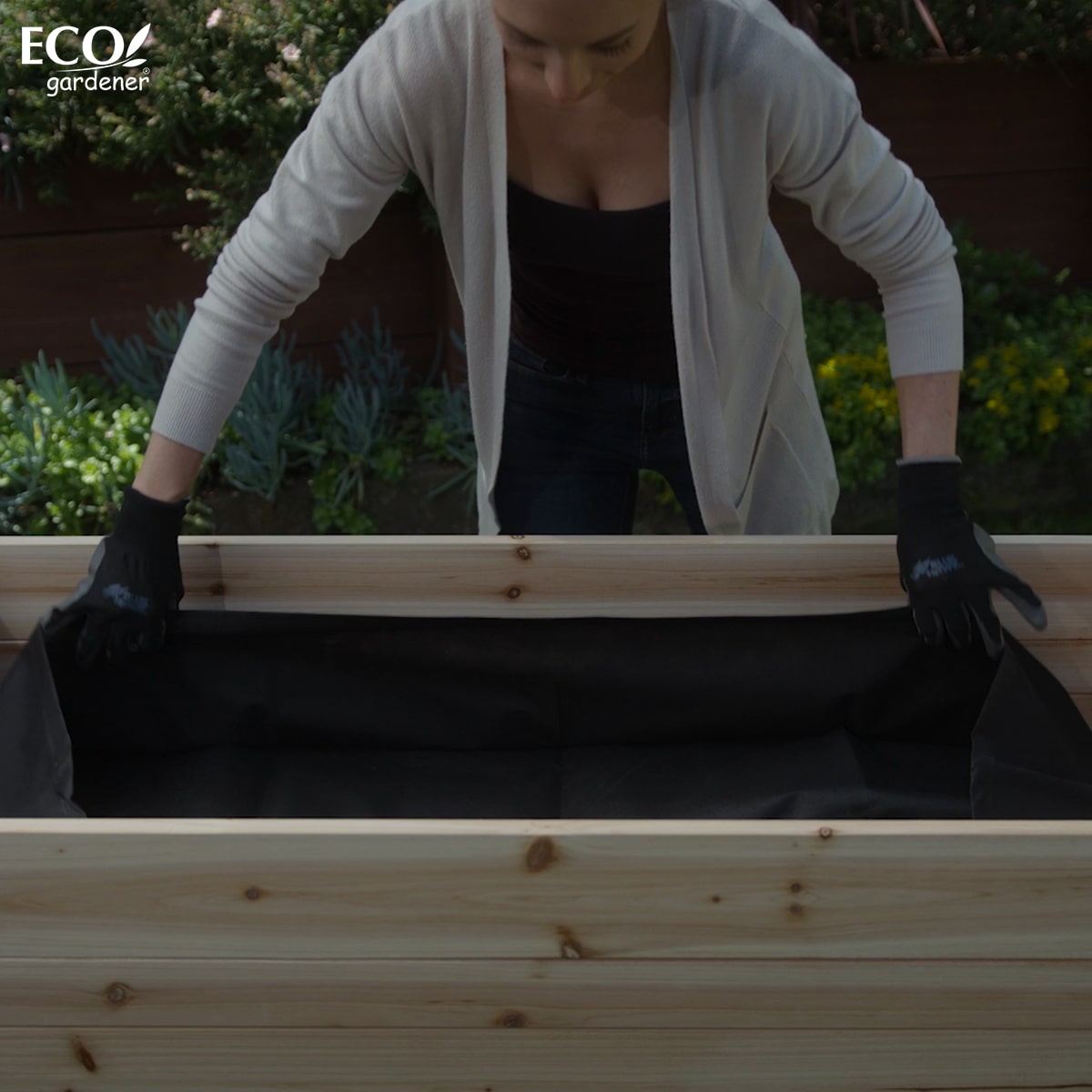 A woman putting a fabric liner for the Ecogardener Elevated Raised Bed