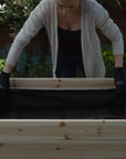 A woman putting a fabric liner for the Ecogardener Elevated Raised Bed