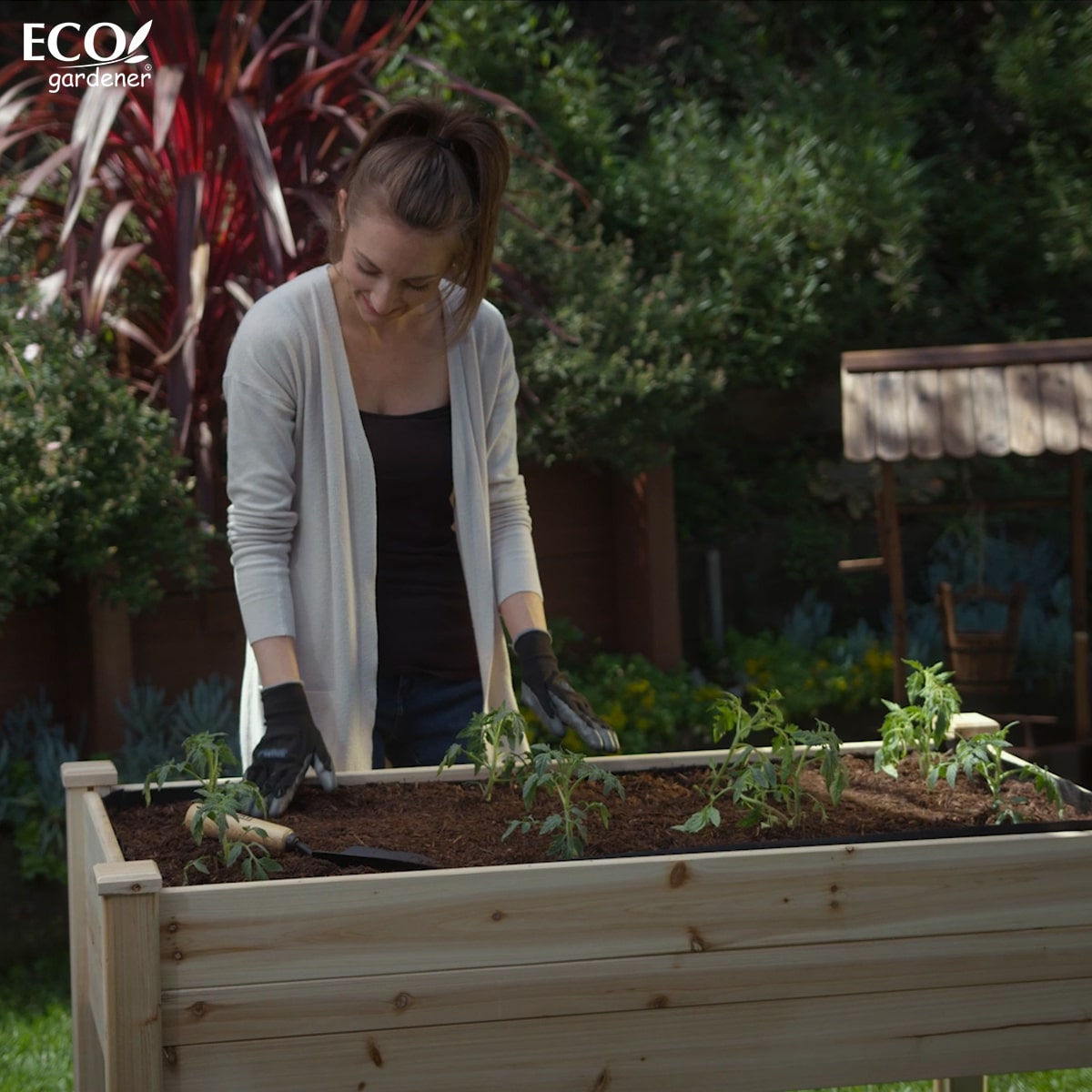A woman checking her plants in Ecogardener Elevated Raised Bed