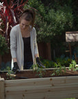 A woman checking her plants in Ecogardener Elevated Raised Bed