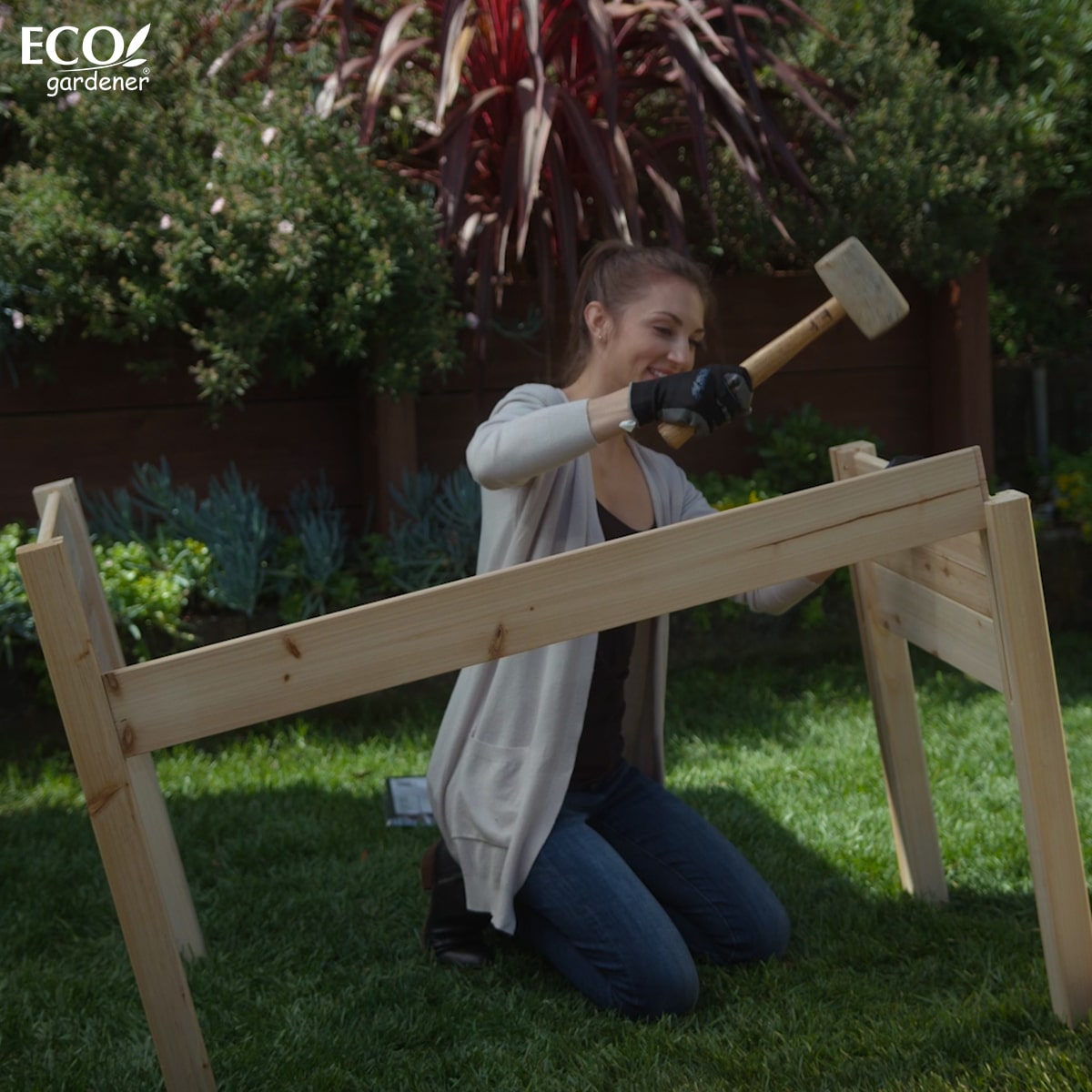 A woman assembling an Ecogardener Elevated Raised Bed