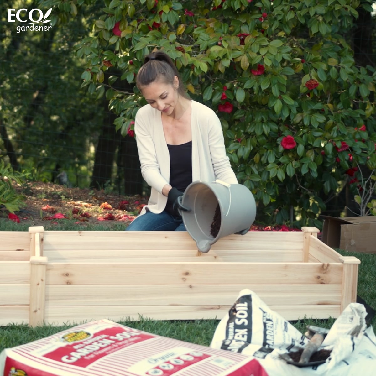 Woman adding soil to the Ecogardener Raised Bed