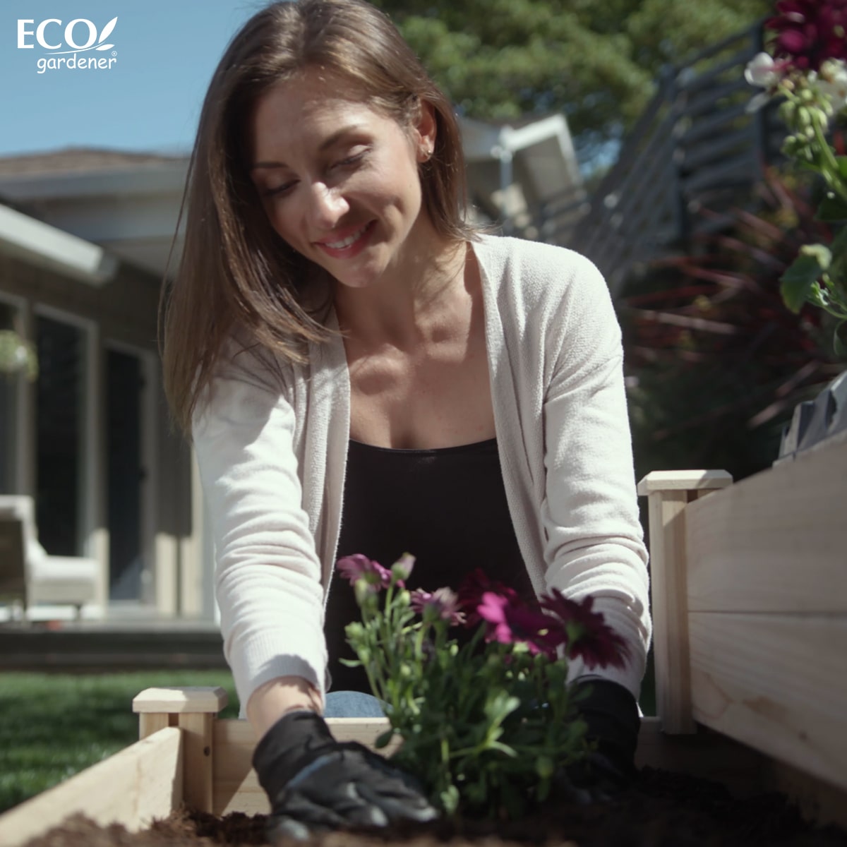 A woman planting on Ecogardener Tiered Raised Bed