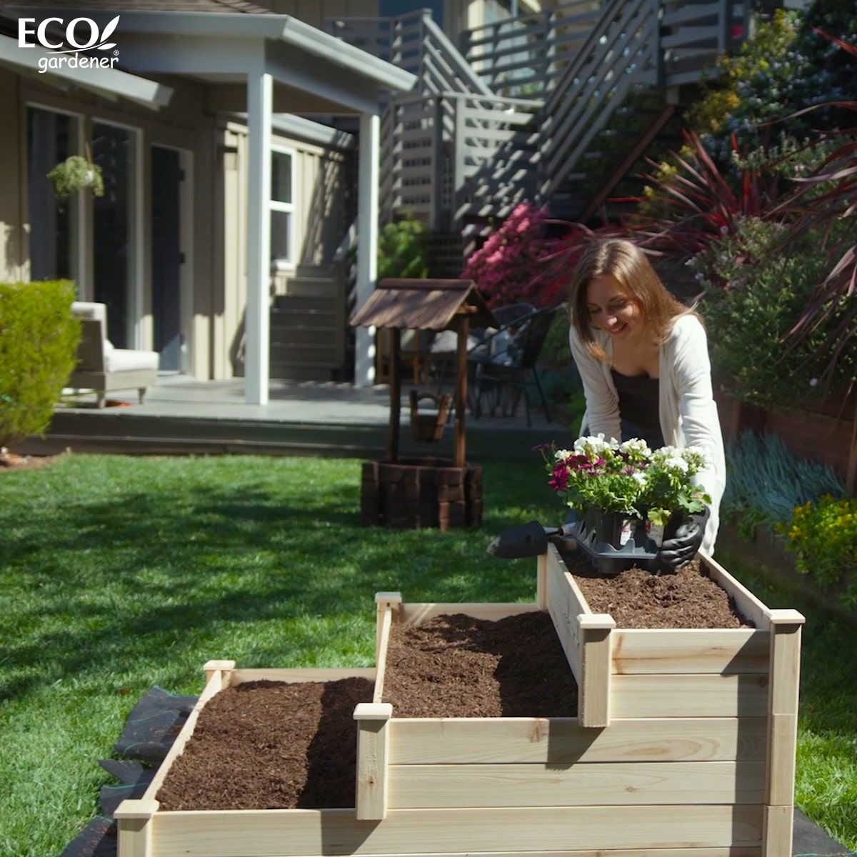 A woman planting in an Ecogardener Tiered Raised Bed Planter.