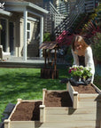 A woman planting in an Ecogardener Tiered Raised Bed Planter.
